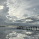 Storm clouds over the water with sunlight breaking through and reflecting on the surface.