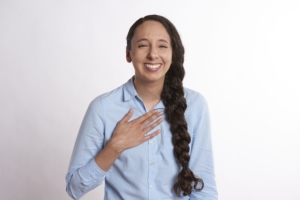 robinhiggins-flattered-2385793 Smiling woman with her hand over her heart representing a whole-person healing approach